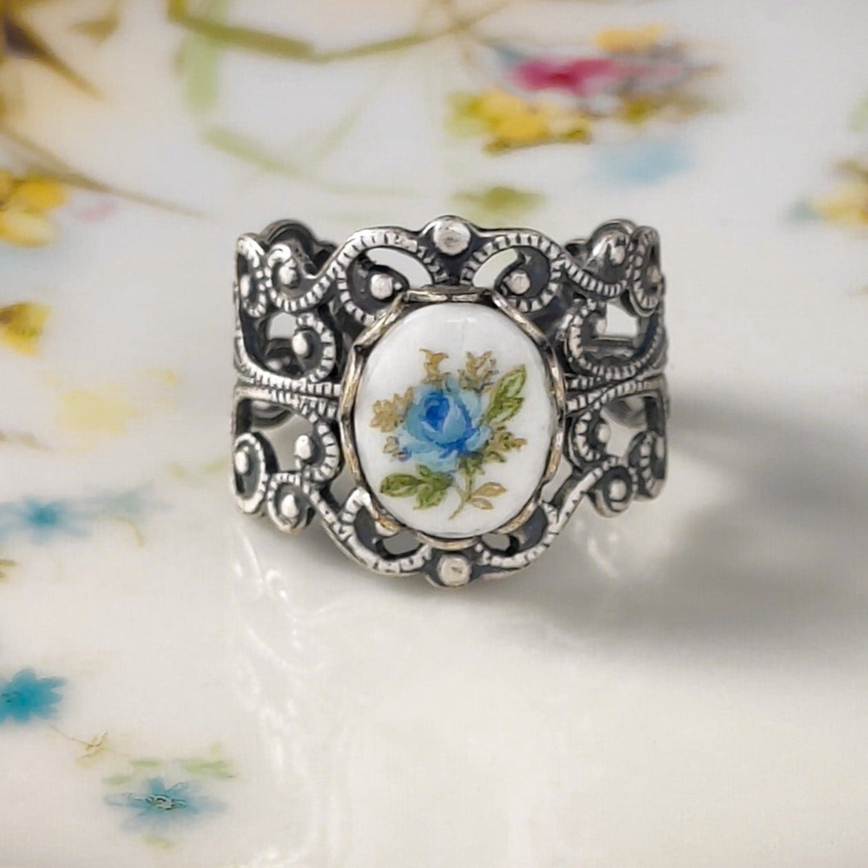 Antiqued silver vintage style adjustable filigree ring with an antique blue rose porcelain cameo.