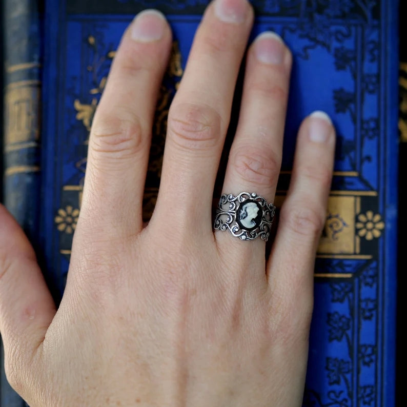 A silver adjustable filigree cameo ring with a black and white profile cameo.