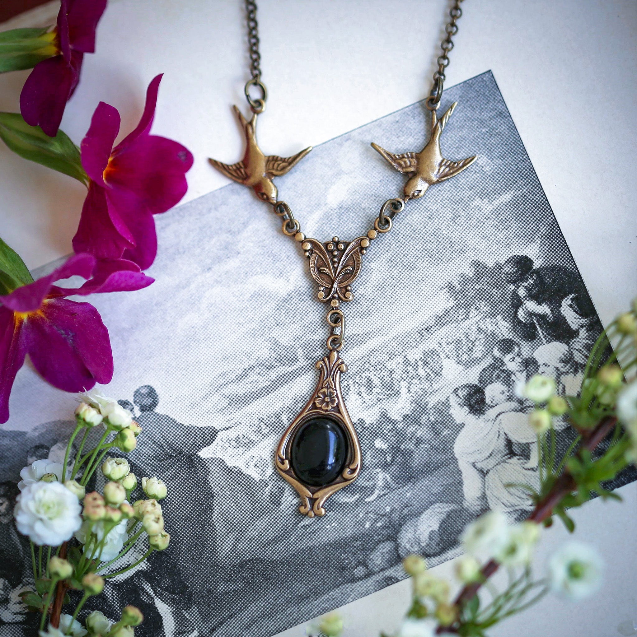 Brass vintage-style necklace with two birds and a black onyx drop pendant.