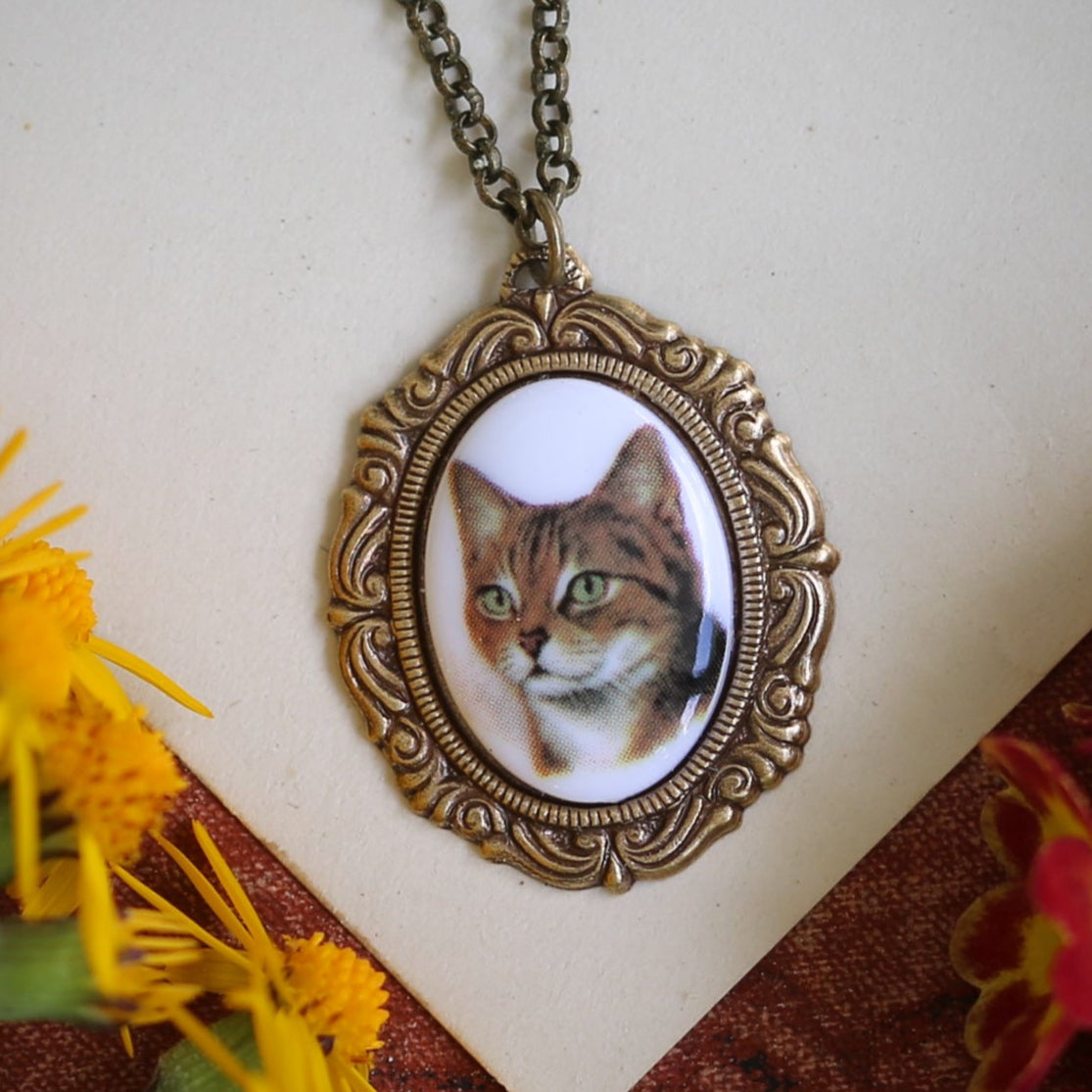 Orange short haired cat cameo on an antiqued brass vintage style necklace by ragtrader vintage.