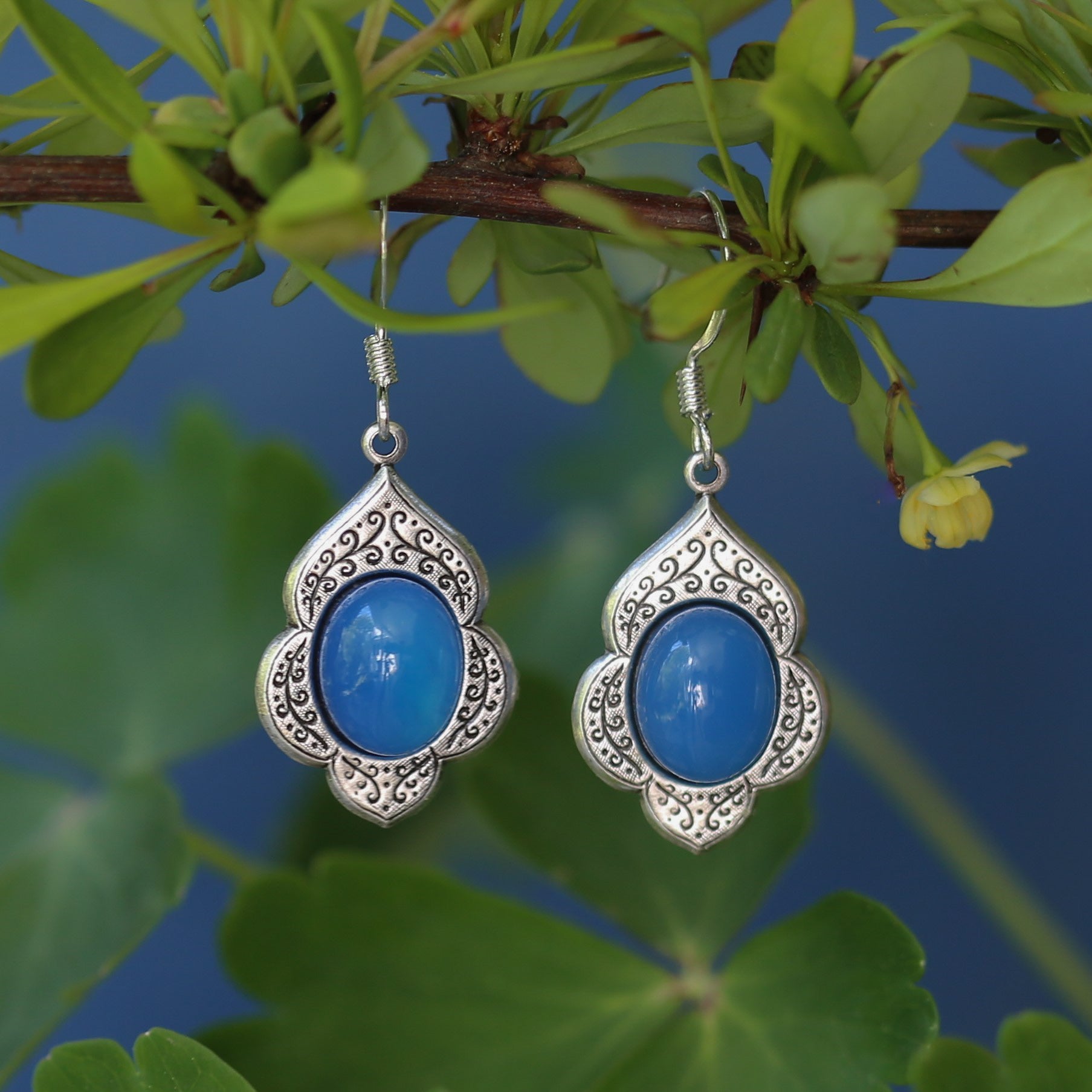antiqued silver vintage style drop dangle earrings with a leaf and vine motif with semi-precious blue agate mineral oval stone cabochons.