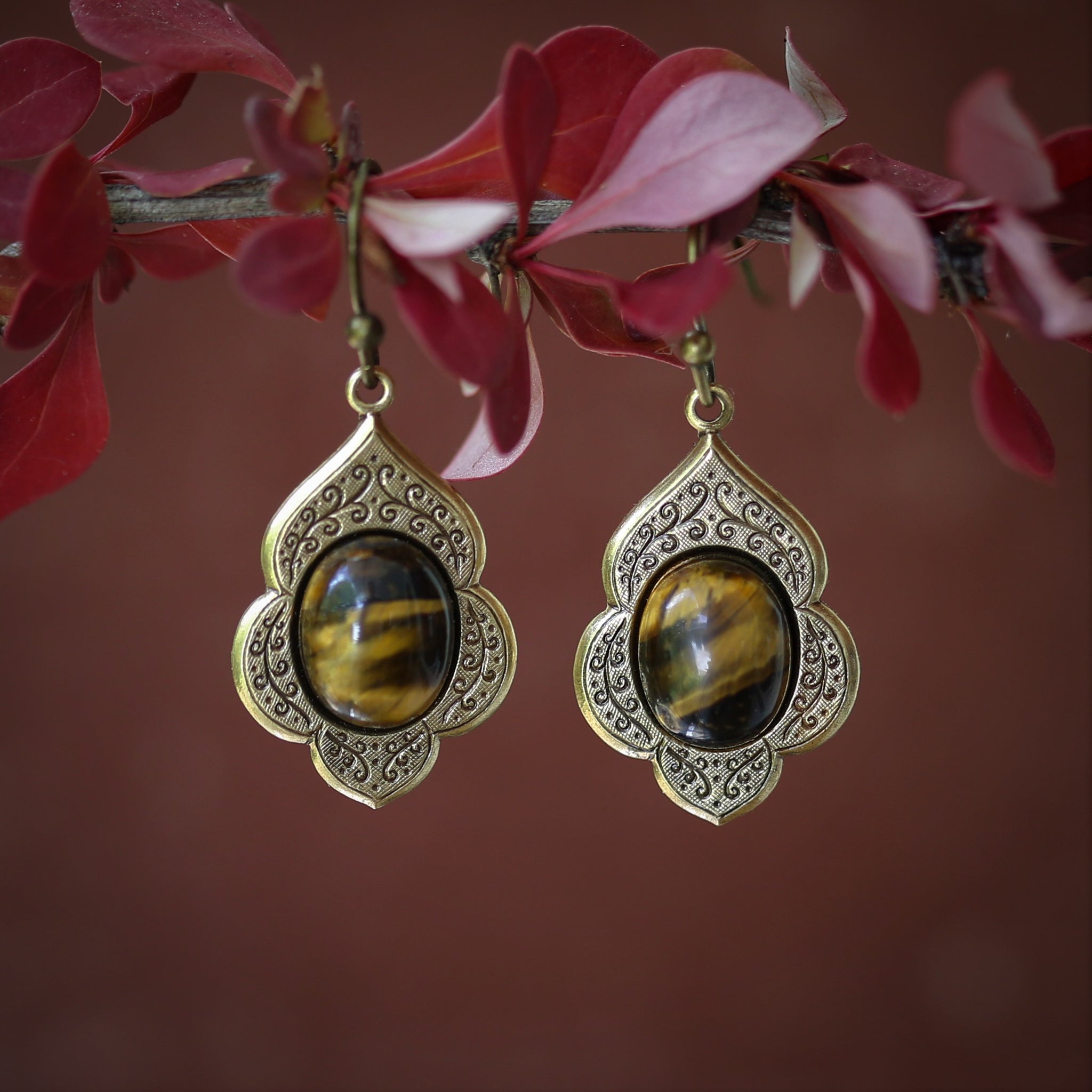 antiqued brass vintage style drop dangle earrings with a leaf and vine motif with semi-precious brown tiger eye mineral oval stone cabochons.