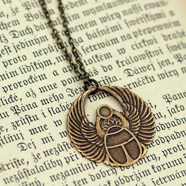 Antiqued brass scarab beetle pendant on a simple chain. Pendant is in a circular Art Deco design.