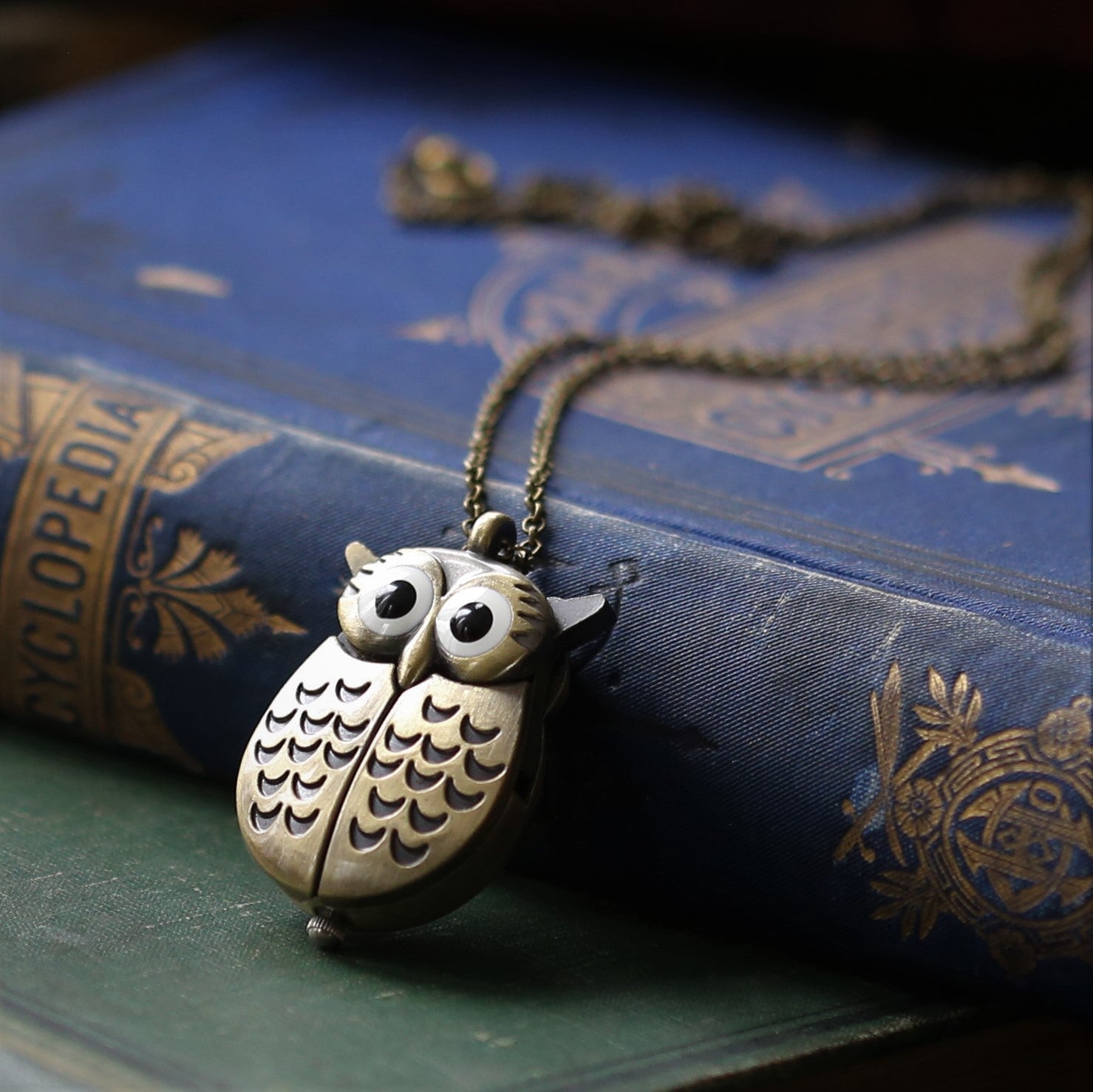 A bronze owl-shaped watch necklace. This watch is closed with the owl's wings covering the watch face.