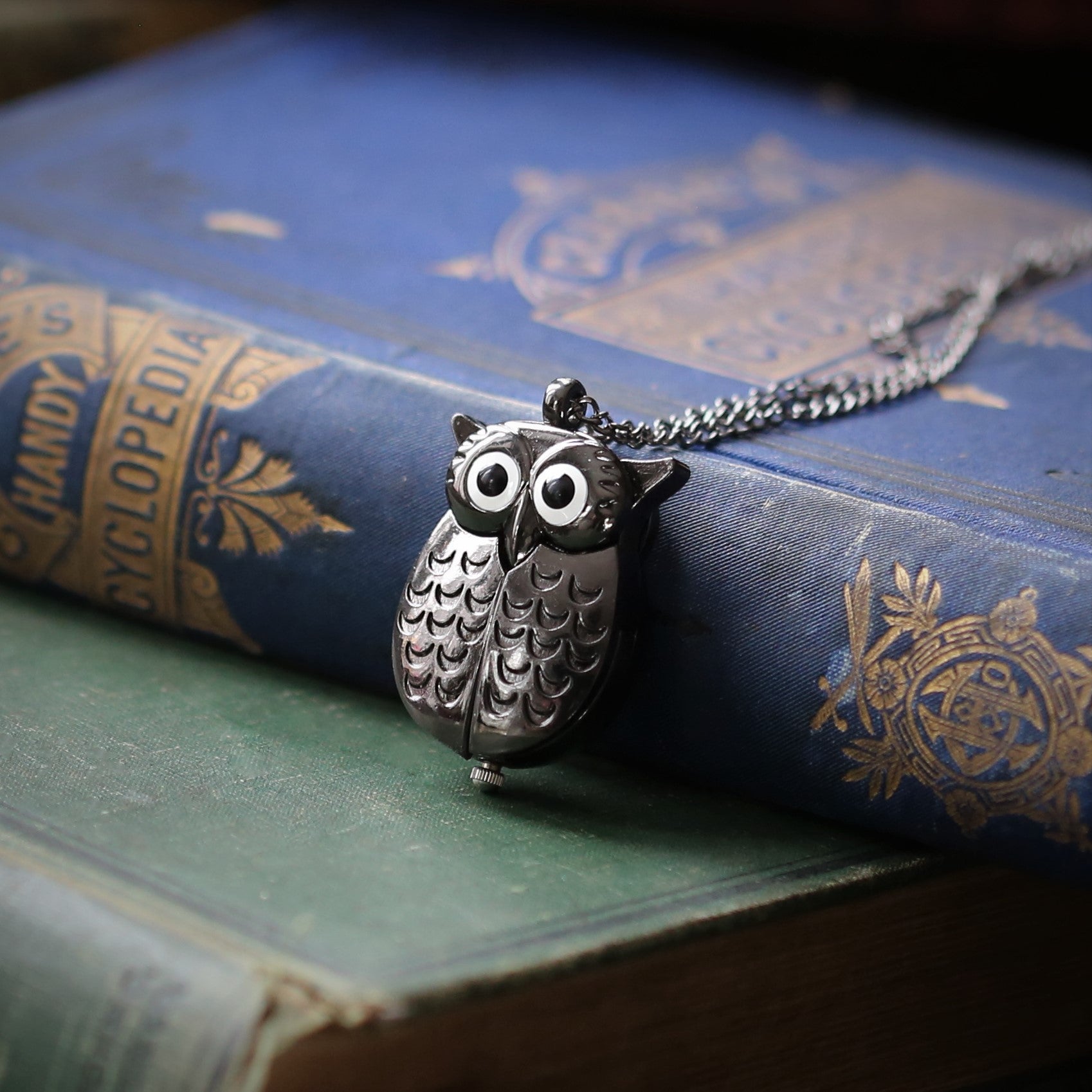 A gun metal owl-shaped watch necklace. This watch is closed with the owl's wings covering the watch face.