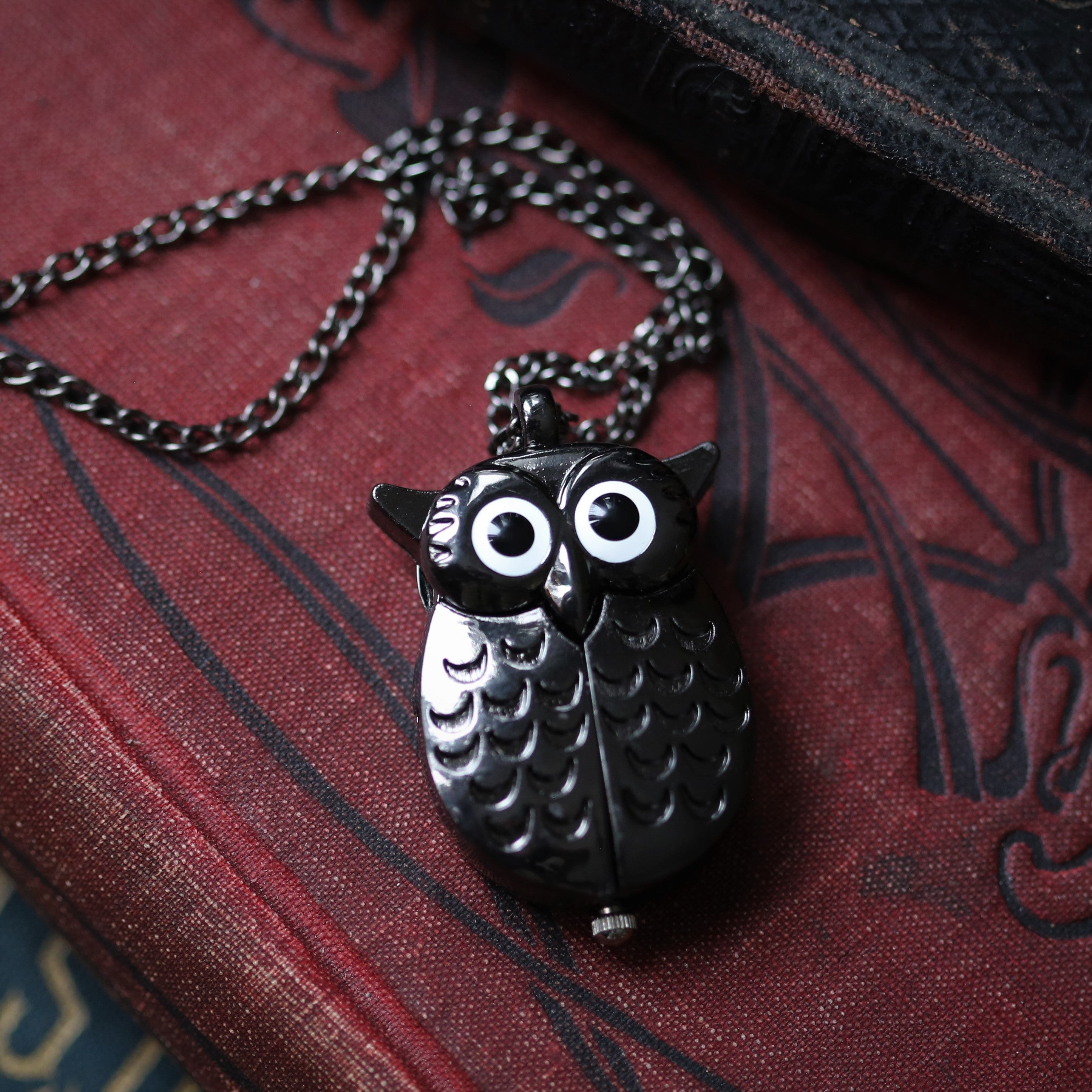 A gun metal owl-shaped watch necklace. This watch is closed with the owl's wings covering the watch face.