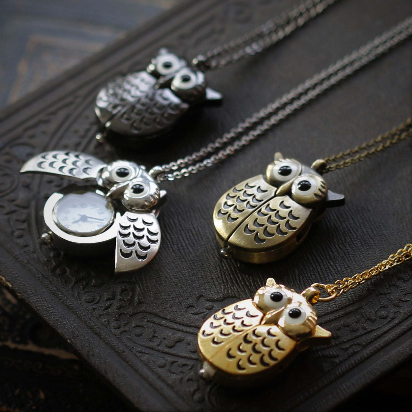 Four owl-shaped watch necklaces displaying the different metal options: Gun Metal, Silver, Bronze, and Gold.
