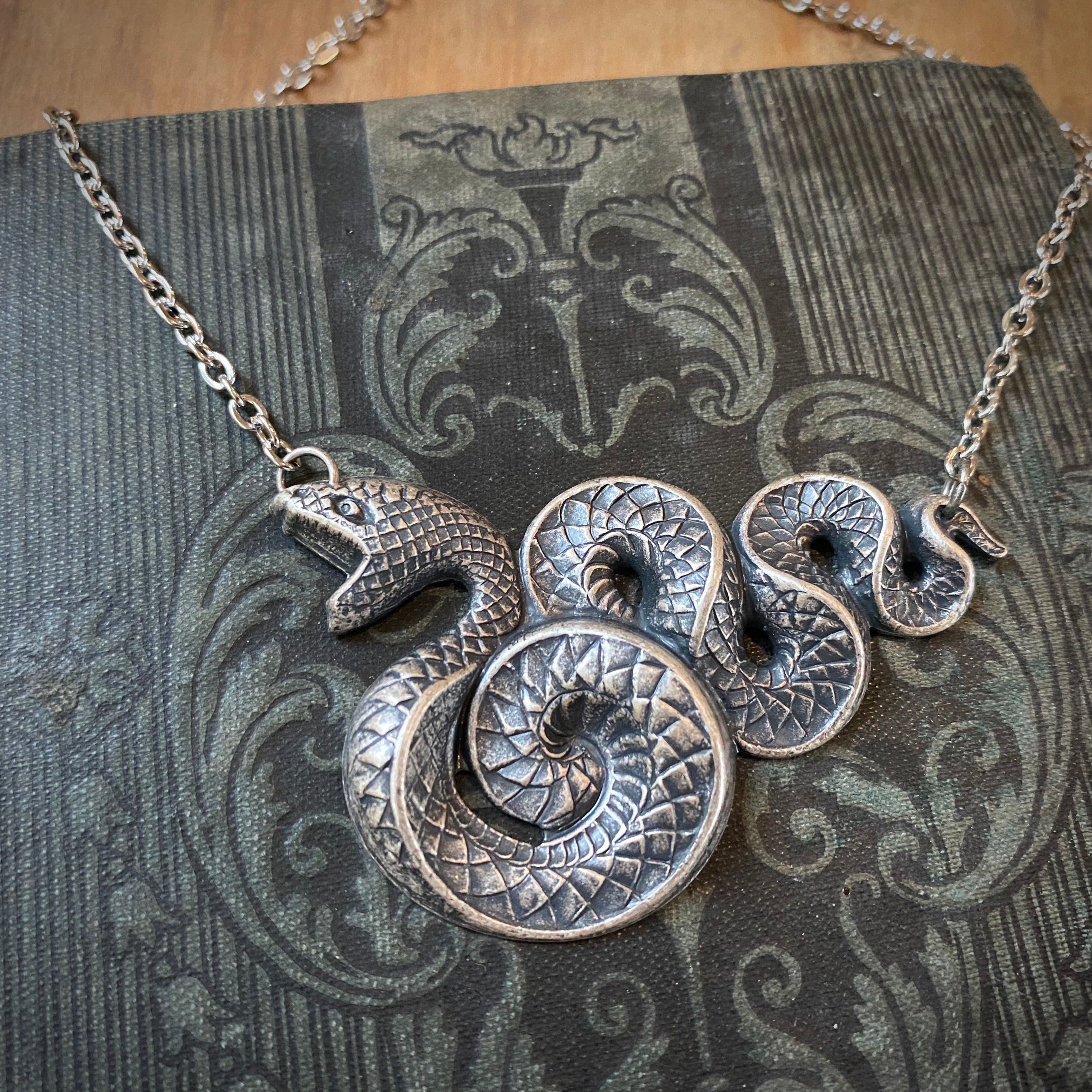 Antiqued brass Victorian snake pendant necklace.