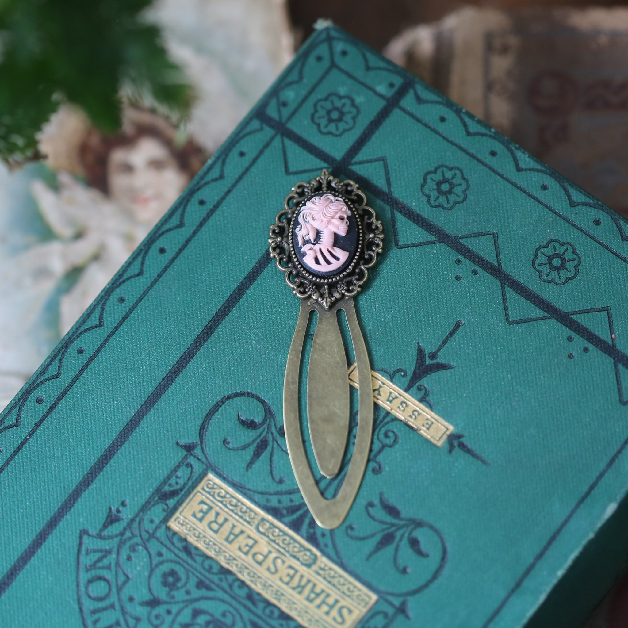 antiqued brass modern vintage inspired clip bookmark page saver with a green skeleton zombie lady Victorian oval cameo for dungeons and dragons lover