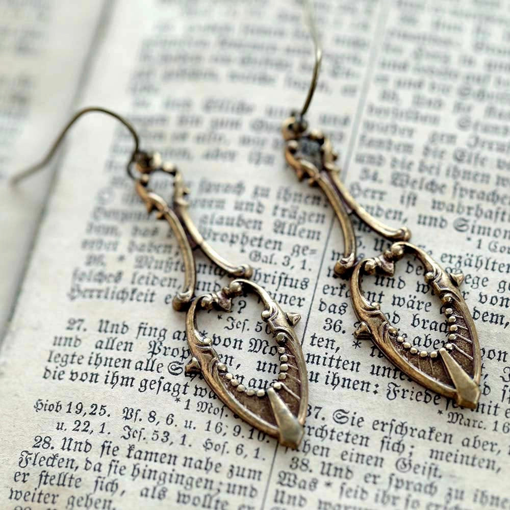 Antiqued brass drop earrings with a art deco cutout design.