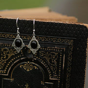 Antiqued silver vintage style art deco dangle stone earrings with black onyx oval mineral.