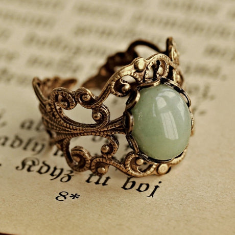 Antiqued brass adjustable vintage style filigree stone ring with green oval mineral.
