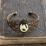 Antiqued brass bronze tone vintage style Victorian adjustable bracelet cuff with a black and white lucky horse and shoe cameo.