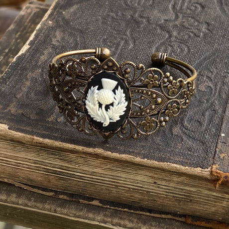 Antiqued brass bronze tone vintage style Victorian adjustable bracelet cuff with a black and white Scottish thistle cameo.