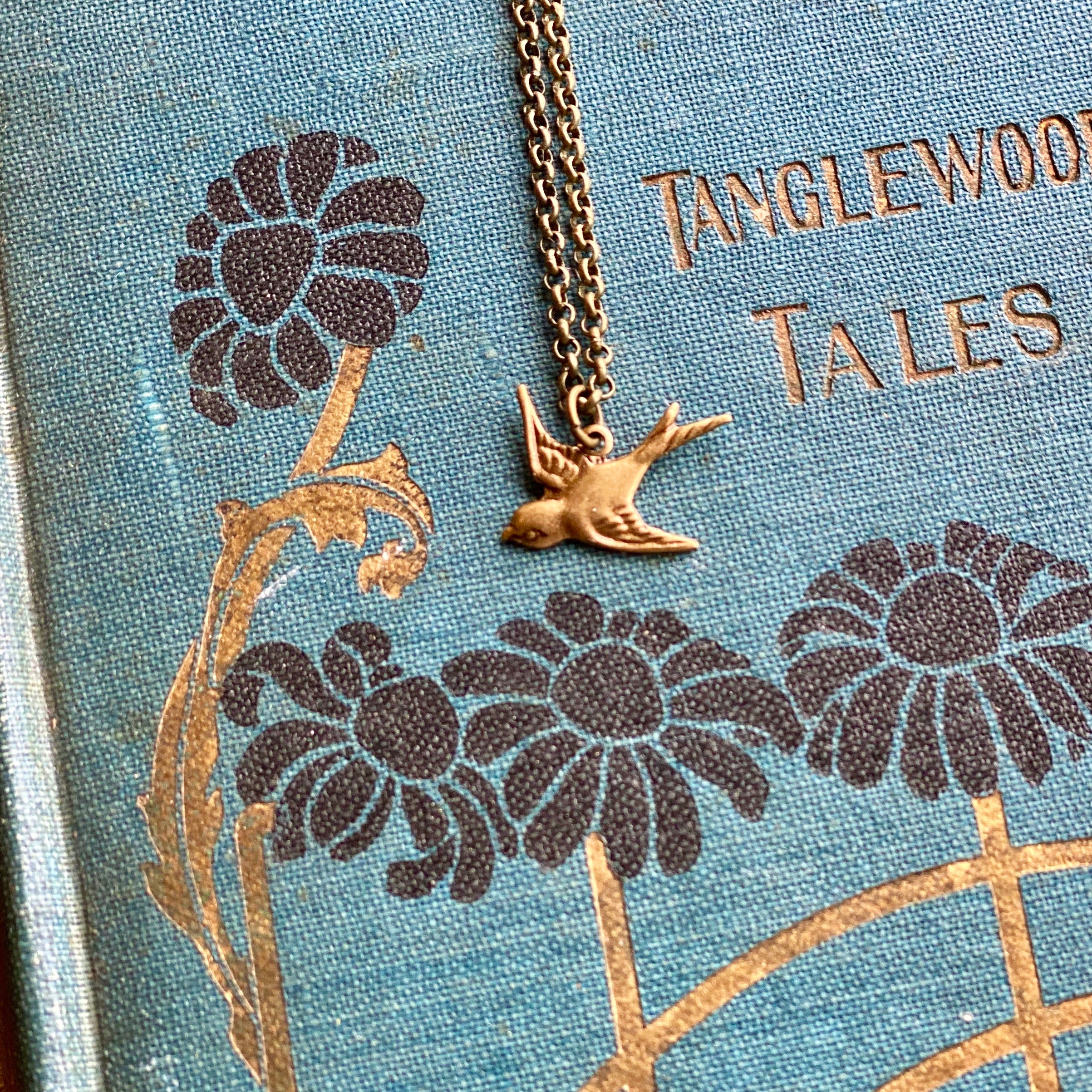 Brass necklace with a flying bird charm