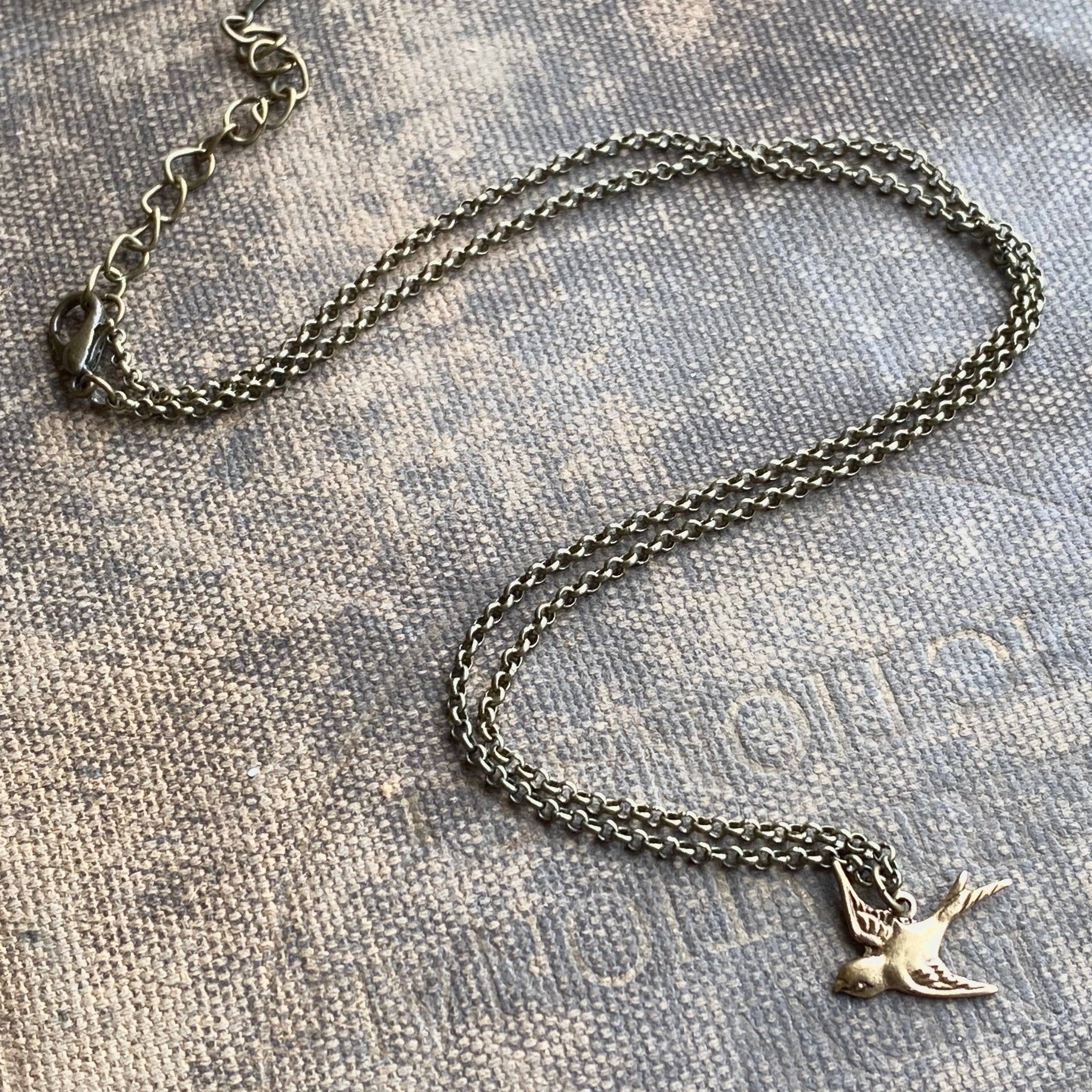 Silver necklace with a flying bird charm