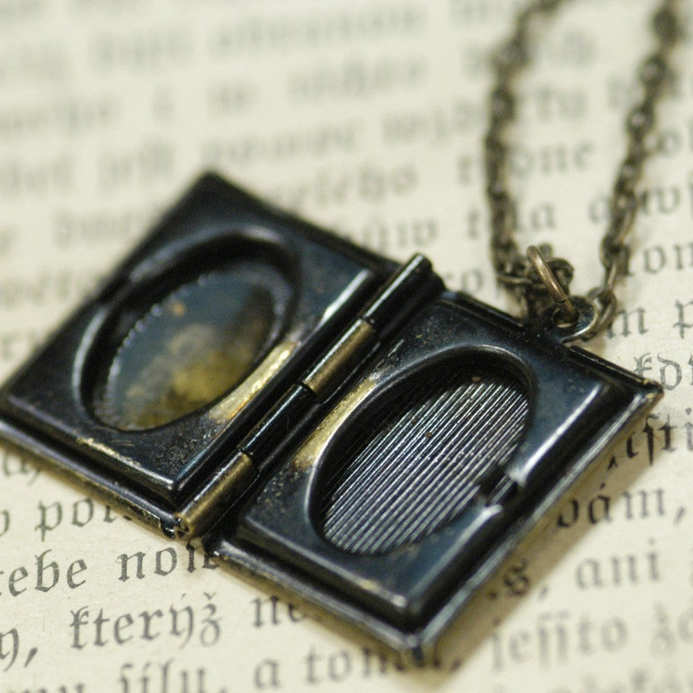 Antiqued brass book locket displayed open