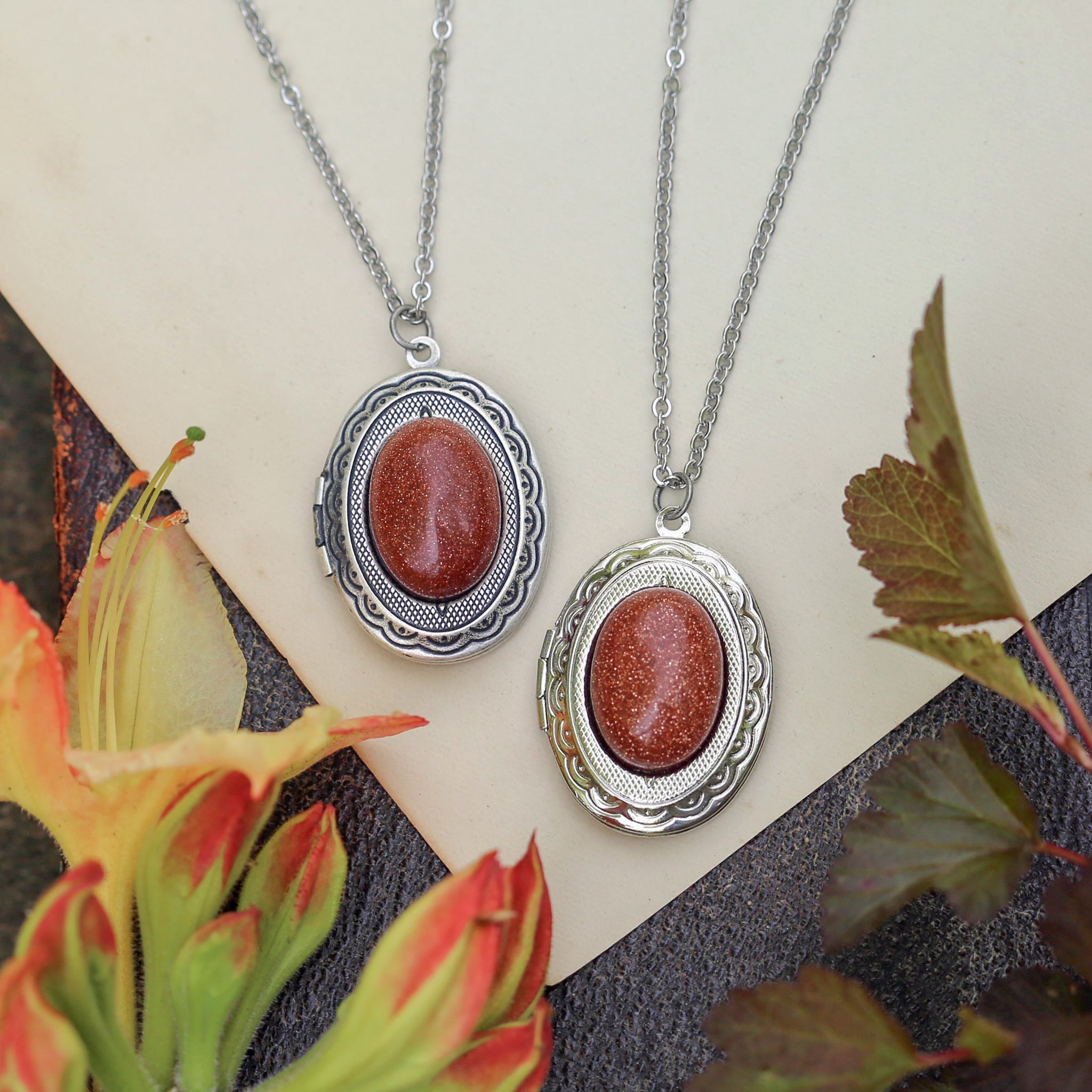 Antiqued silver renaissance era long oval orange goldstone semi-precious stone mineral locket in bold autumnal winter academia style making a great sentimental gift for your loved one.