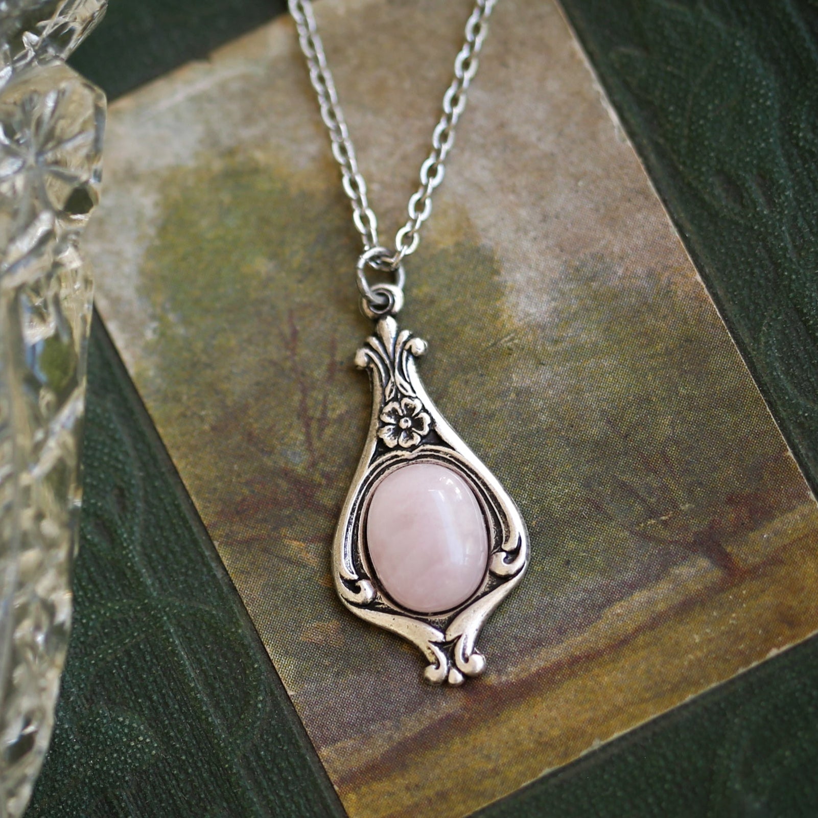 Antiqued silver vintage-inspired small clean girl aesthetic necklace with a dainty pink rose quartz stone on a mini floral drop setting.