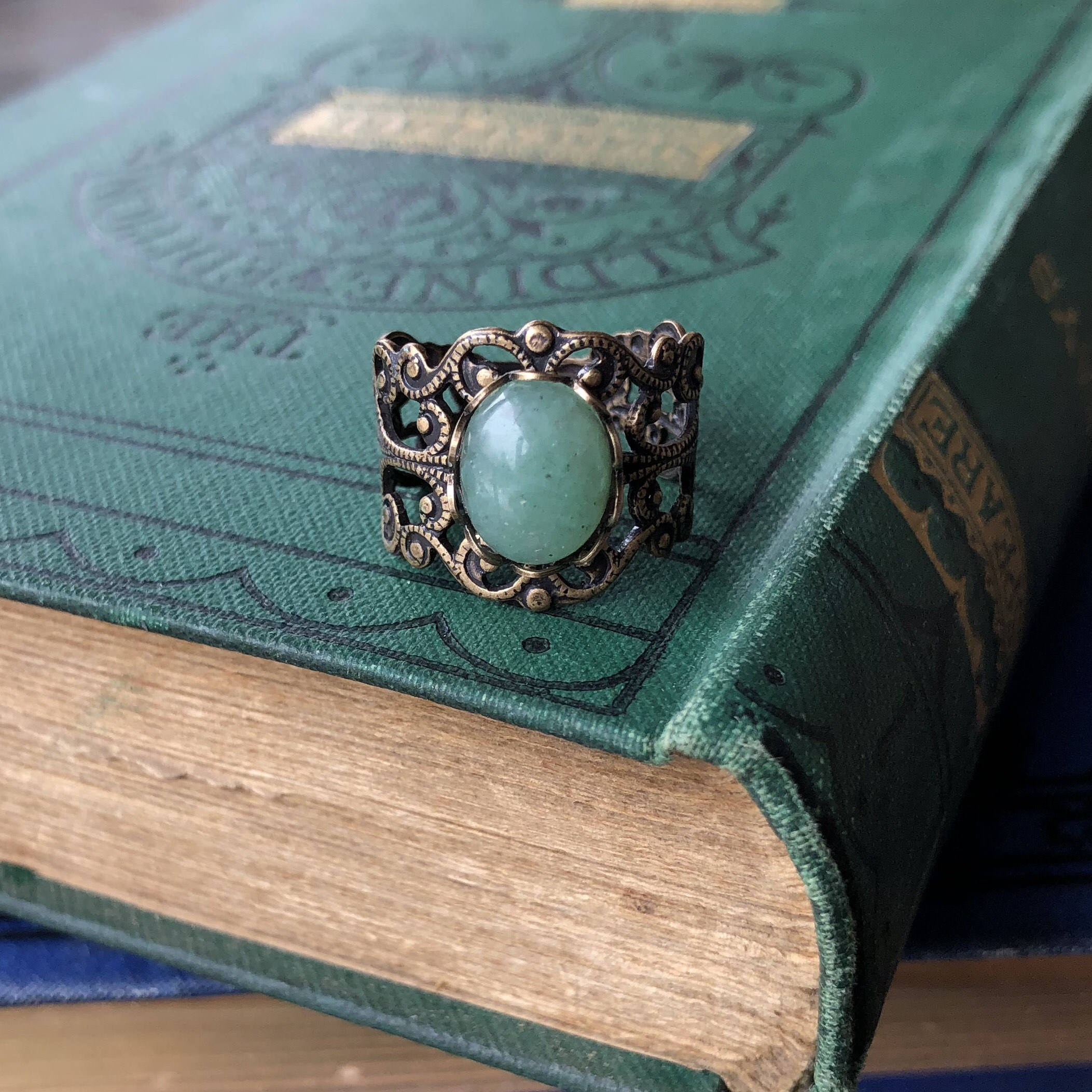 Antiqued brass modern vintage inspired adjustable filigree cocktail ring with a green aventurine semi-precious stone in the christian girl style.