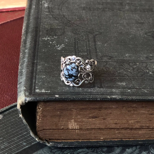 rich antiqued silver modern vintage inspired adjustable filigree ring with a dark black and gray mottled snowflake obsidian oval semi-precious mineral stone set in a gothic aesthetic
