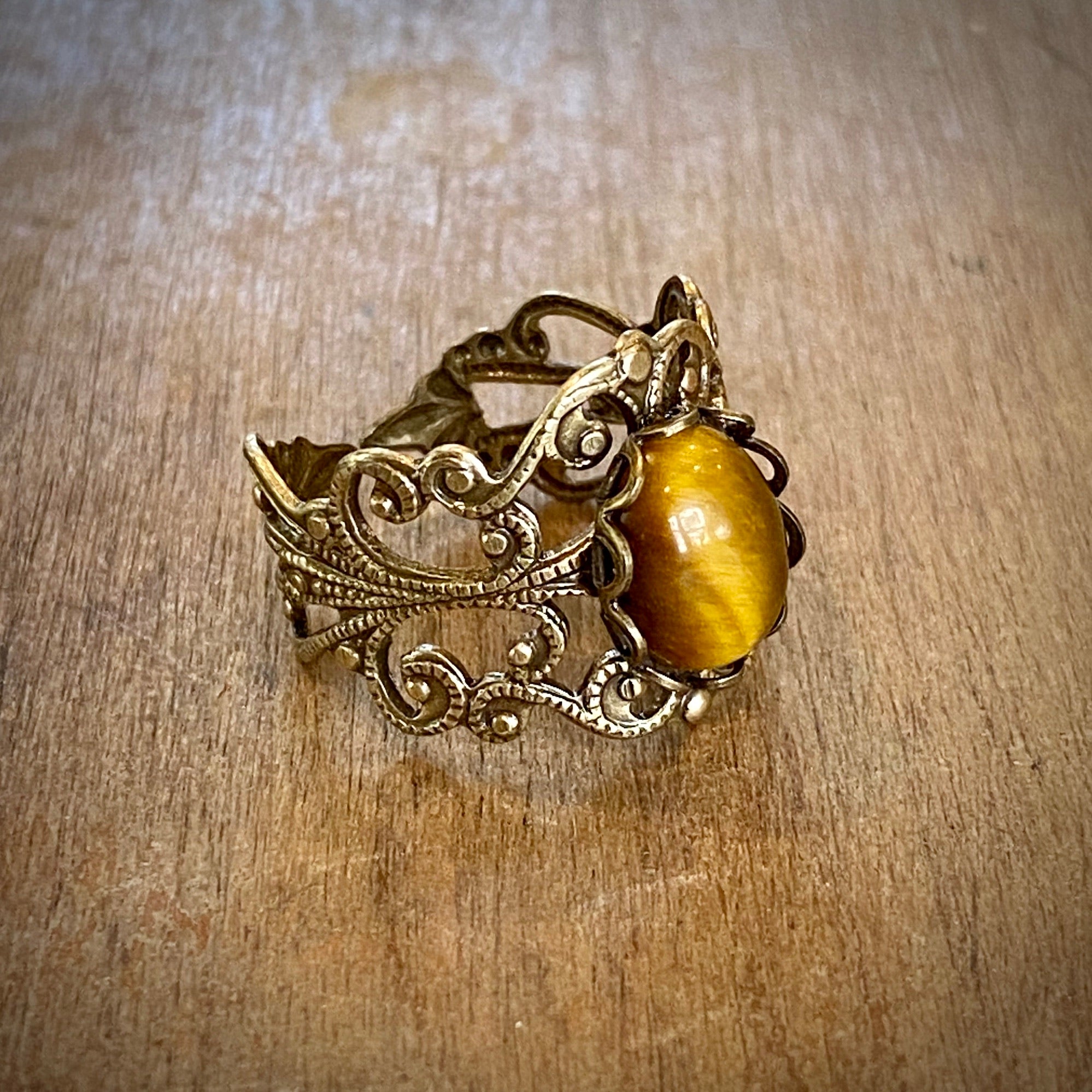 antiqued brass mod vintage inspired resizeable filigree ring with brown oval tiger eye semi-precious stone mineral perfect for a desert wave outfit.