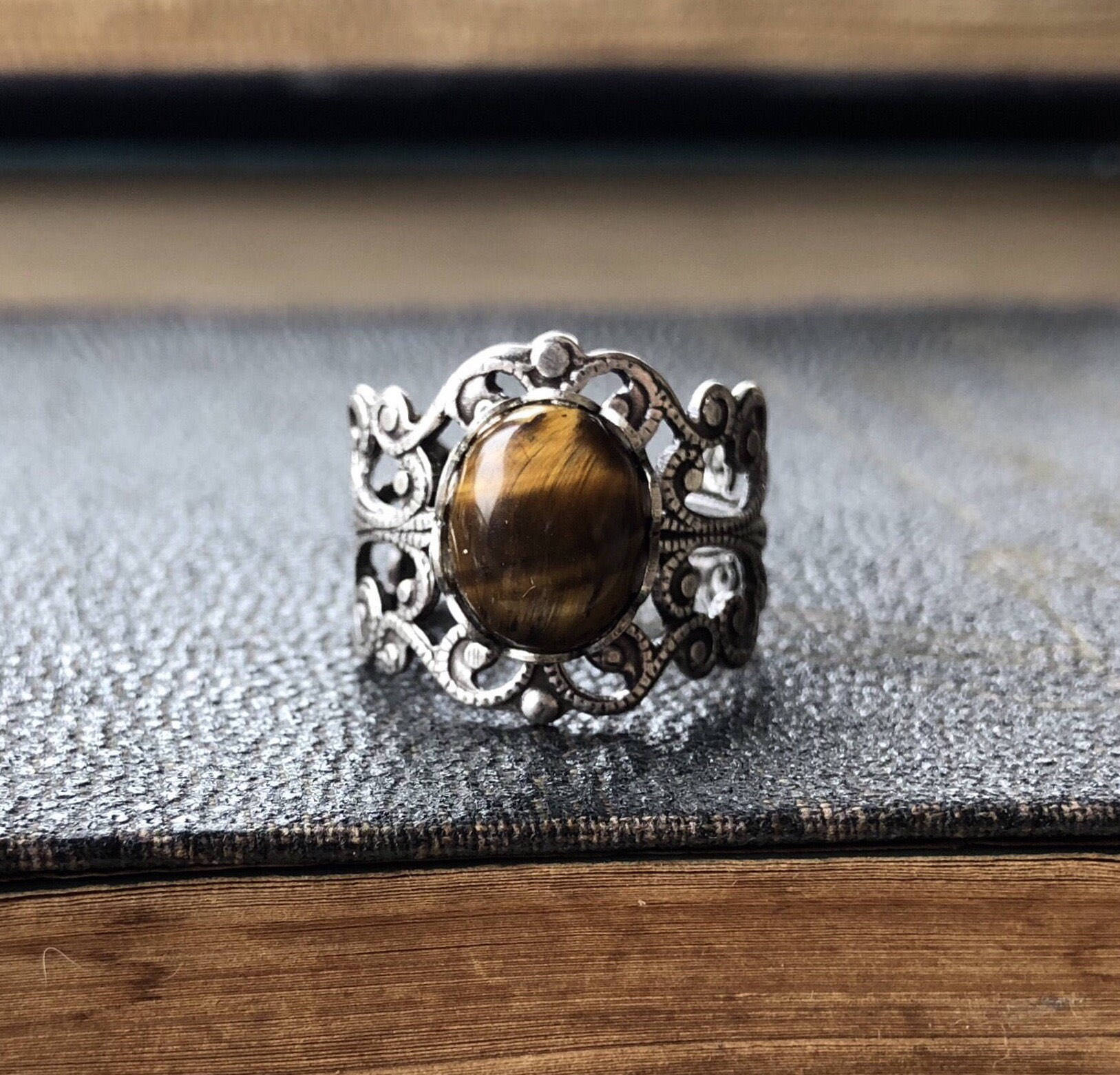 antiqued silver modern vintage inspired adjustable filigree ring with brown oval tiger eye semi-precious stone mineral perfect for an autumn academia outfit.