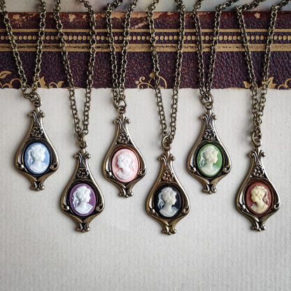 Antiqued brass necklaces with purple, orange, green, blue, pink, and black cameos of women on filigree drop settings.