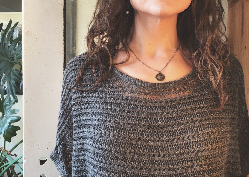 Circular brass pendant on a brass chain on a model