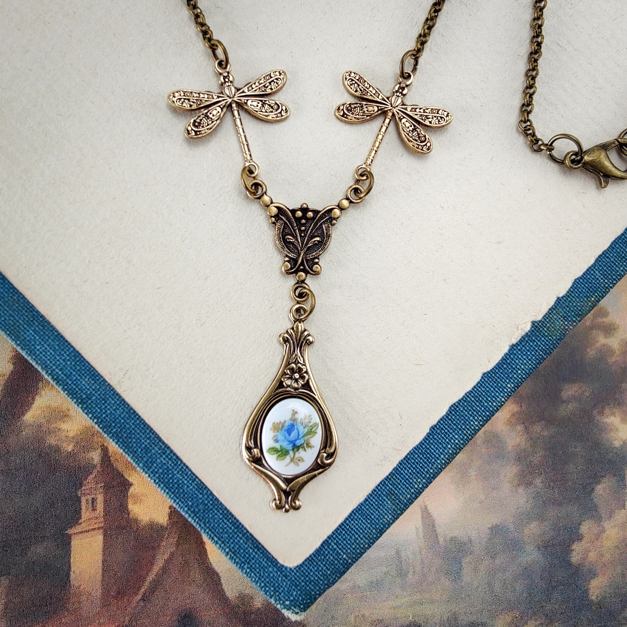 Antiqued vintage style dragonfly filigree teardrop necklace with antique ceramic rose cameo.