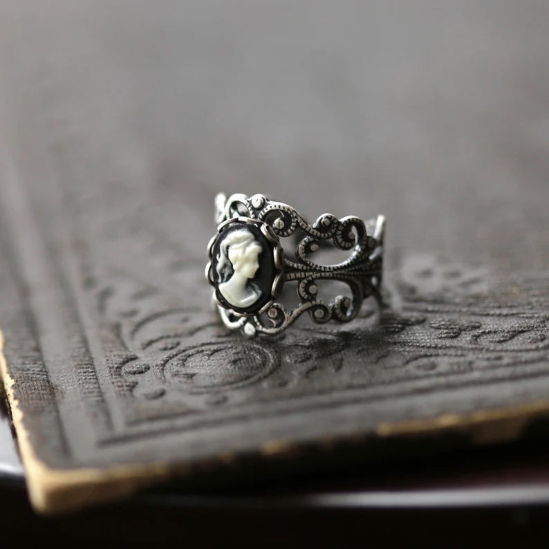 A silver adjustable filigree cameo ring with a black and white profile cameo.