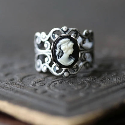 A silver adjustable filigree cameo ring with a black and white profile cameo.