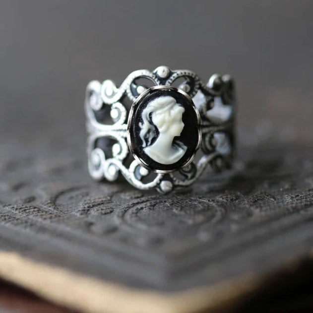 A silver adjustable filigree cameo ring with a black and white profile cameo.