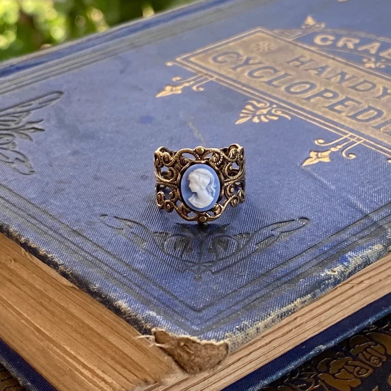 Antiqued brass adjustable filigree ring with bule and white lady cameo.