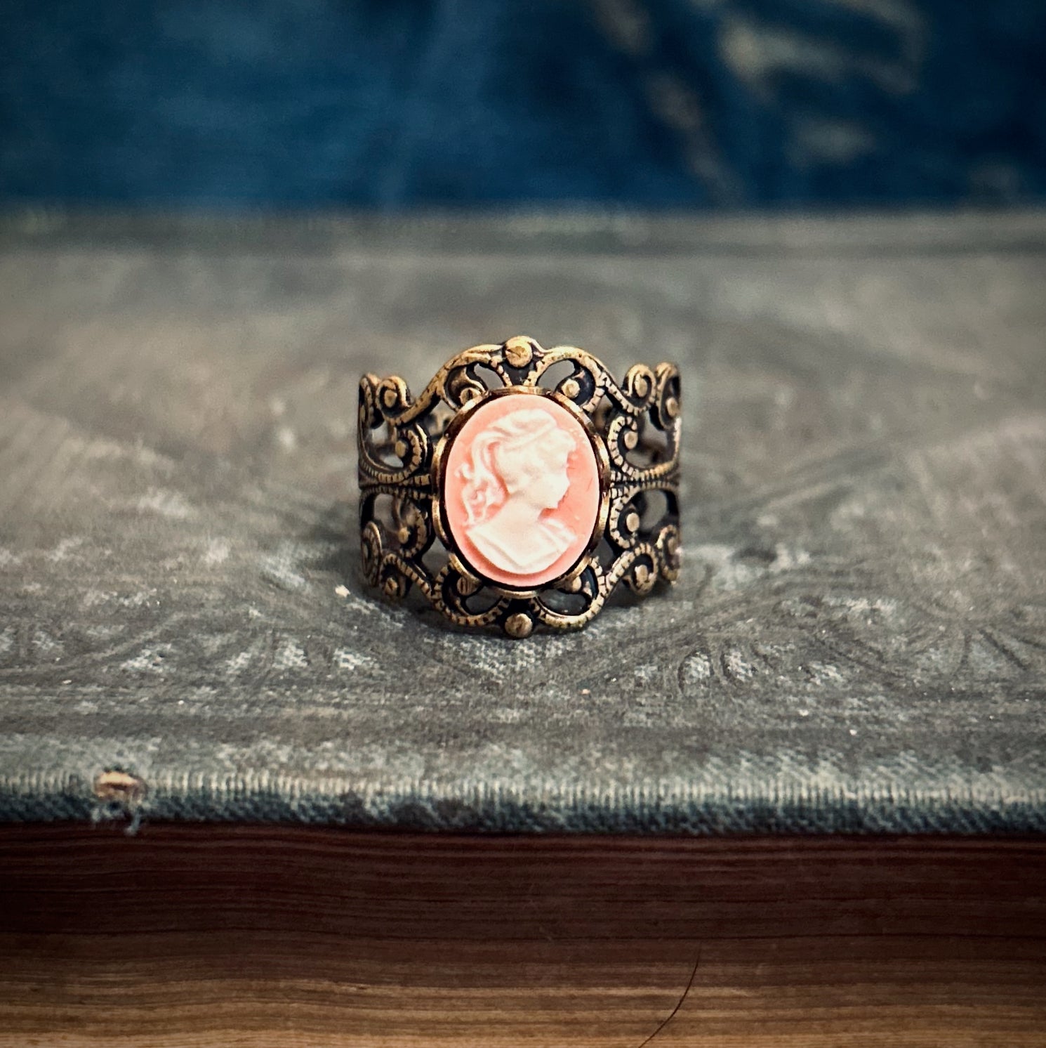 Antiqued brass adjustable filigree ring with peach and white lady cameo.