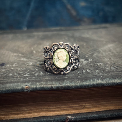 A silver adjustable filigree cameo ring with a green and white profile cameo.