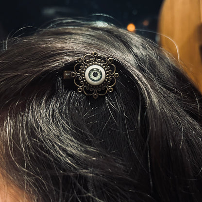 antiqued brass filigree green eyeball hair clips in otherworldly style