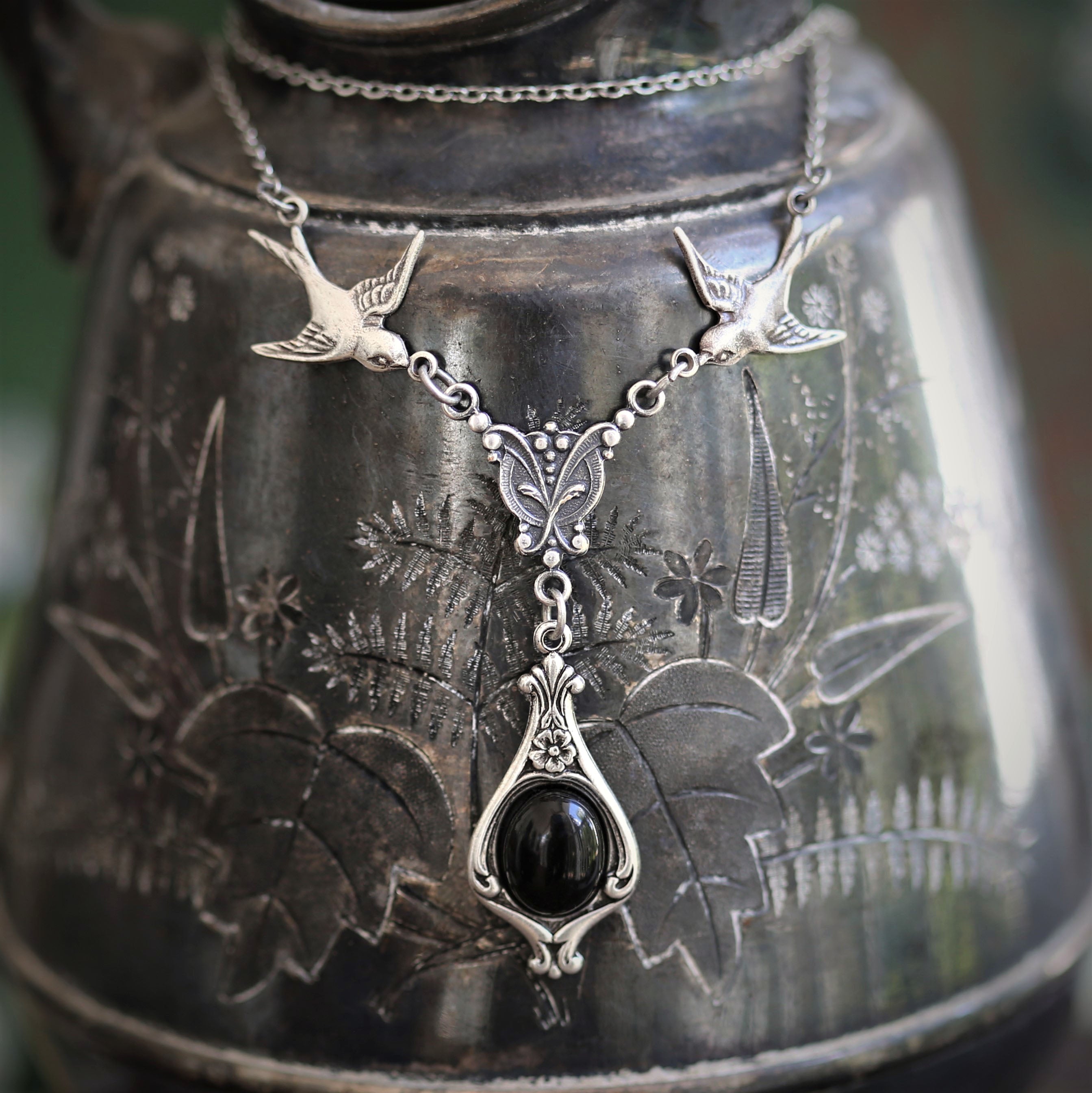 Silver vintage-style necklace with two birds and a black onyx drop