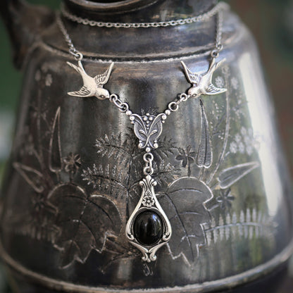 Silver vintage-style necklace with two birds and a black onyx drop