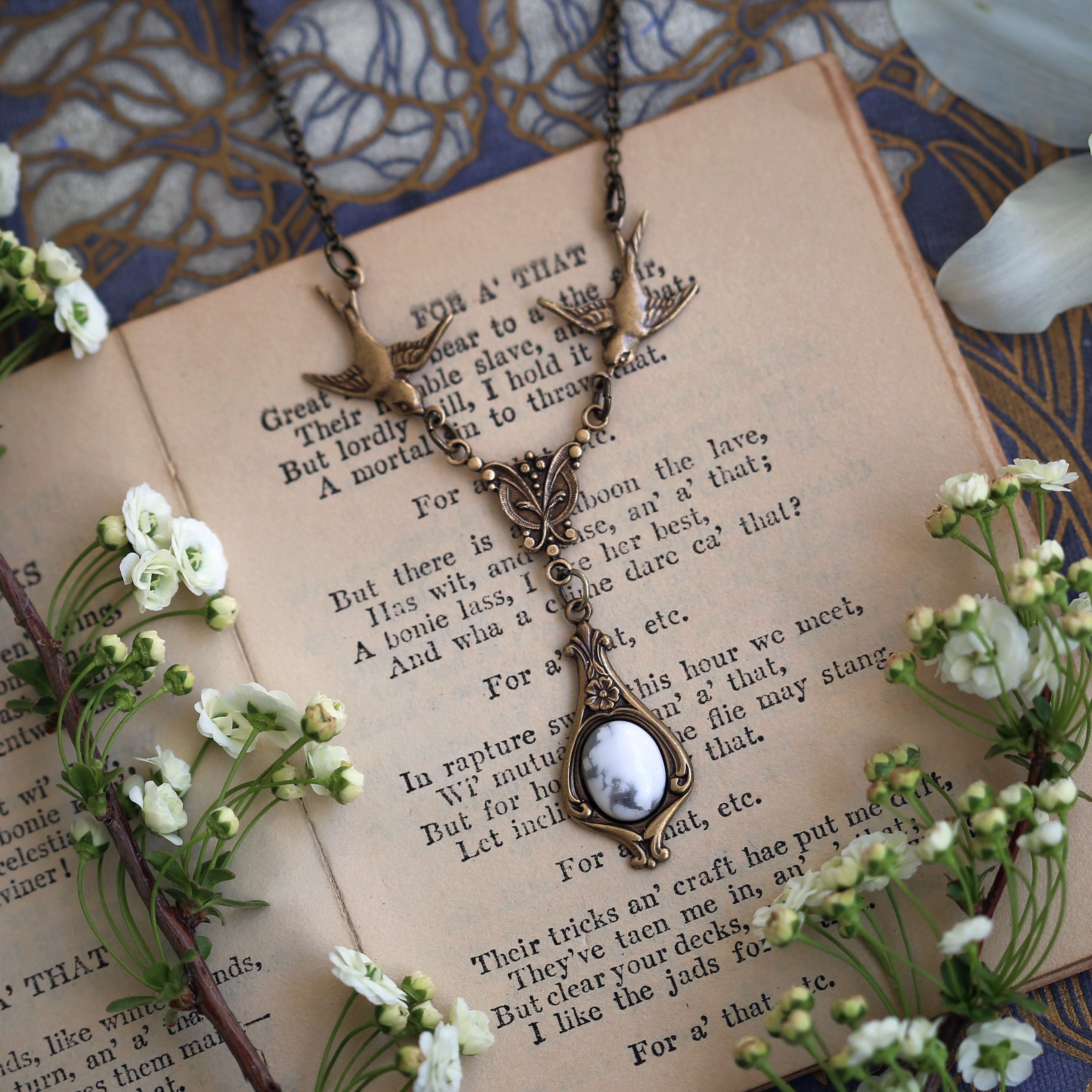 small antiqued brass vintage-style white howlite stone drop pendant with birds in winter academia style