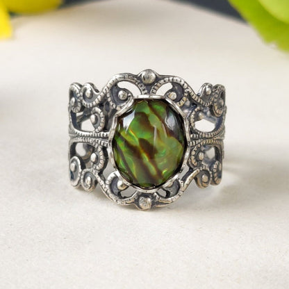 antiqued silver modern vintage style adjustable filigree ring with an iridescent green oval shell in the indie aesthetic