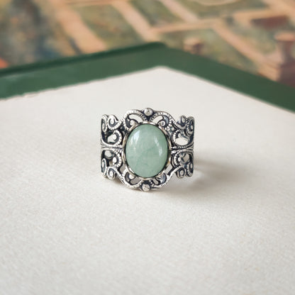 Antiqued brass modern retro inspired adjustable filigree cocktail ring with a green aventurine semi-precious stone in the danish pastel style.  