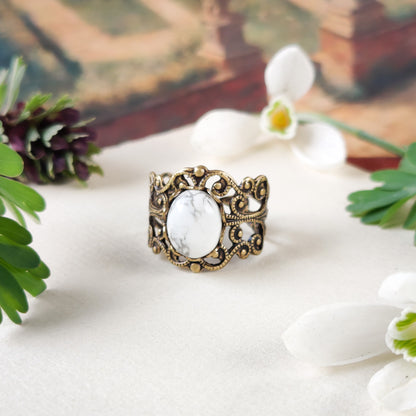 rich bronze colored antiqued brass modern vintage inspired adjustable filigree ring with a white marble howlite semi-precious mineral oval stone in the neo romantism aesthetic
