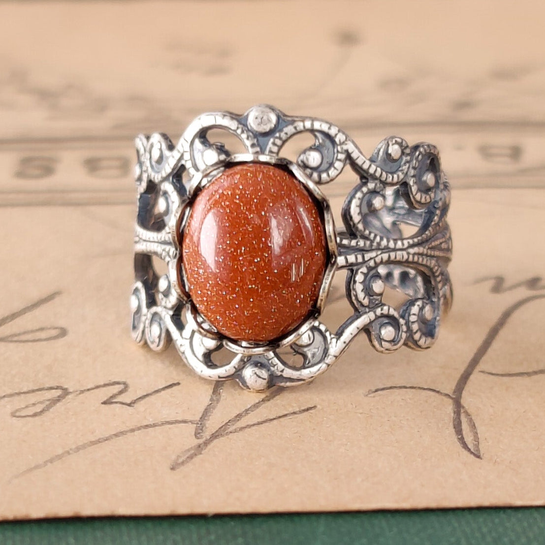 Antiqued brass modern vintage inspired adjustable filigree ring set with an orange goldstone semi-precious mineral in the timeless antique look aesthetic