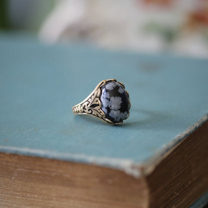 antiqued brass vintage-stye adjustable cocktail ring with black and grey snowflake obsidian oval stone cabochon in Raven core style