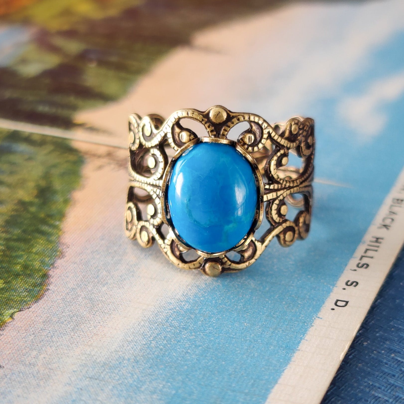 antiqued brass modern vintage inspired resizable filigree statement ring with a turquoise blue howlite oval semi-precious mineral stone in the soft girl fashion aesthetic.