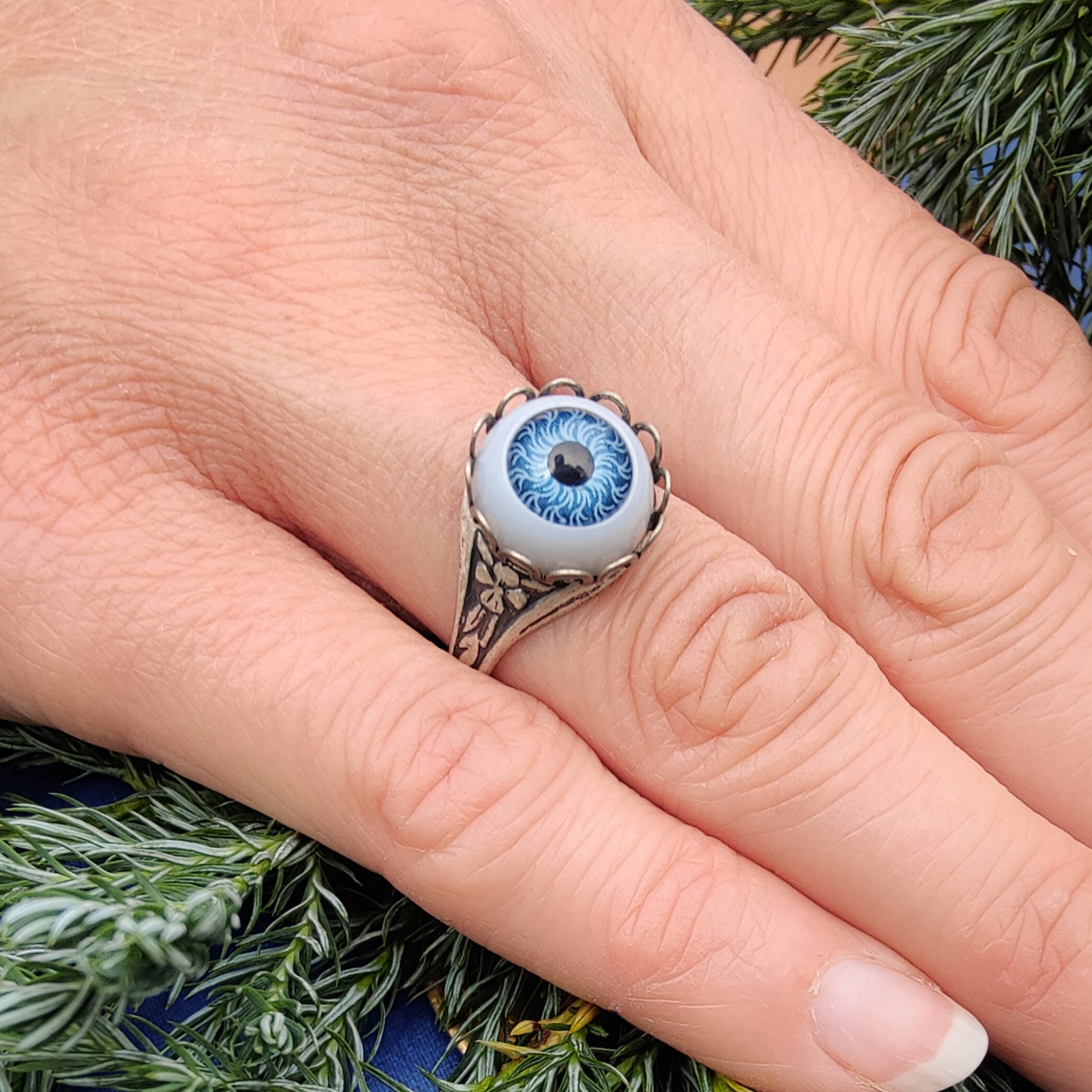 antiqued silver steampunk resizeabel otherworldly zombie cocktail ring with a bright blue doll's all knowing eye.