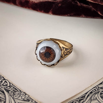 antiqued brass victorian gothic adjustable otherworldly spooky cocktail ring with a brown doll's evil eye.