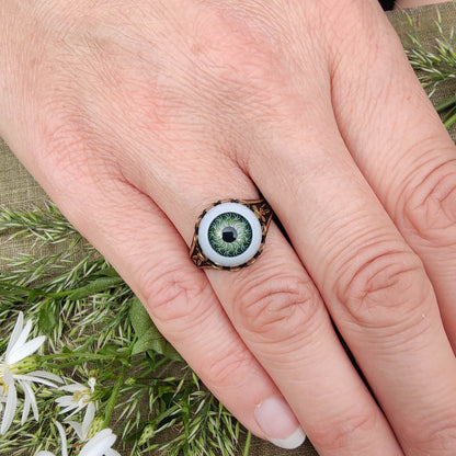 antiqued brass goblin academia adjustable halloween statement ring with a green doll's evil eye.