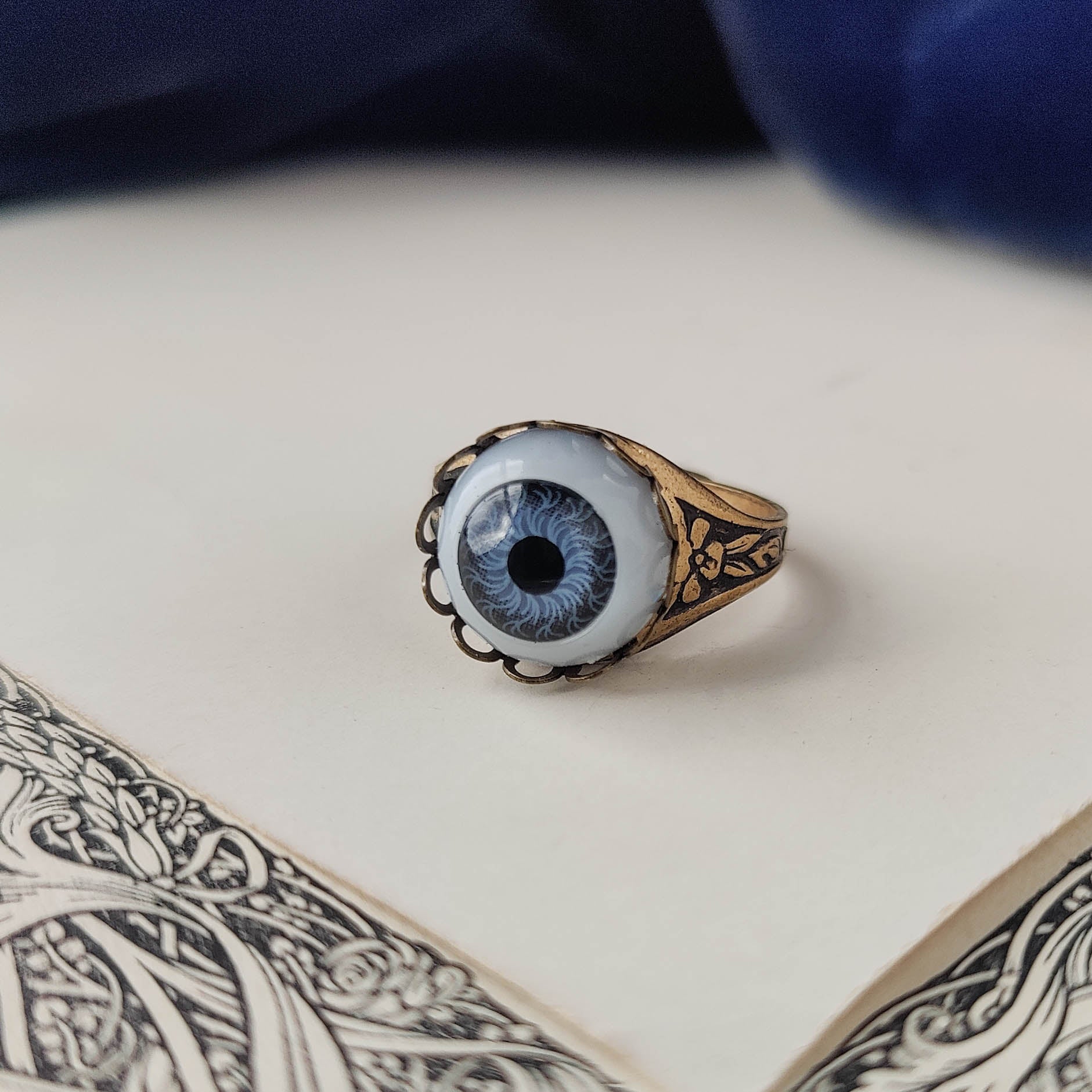 antiqued brass victorian gothic adjustable otherworldly spooky cocktail ring with a light blue doll's evil eye.